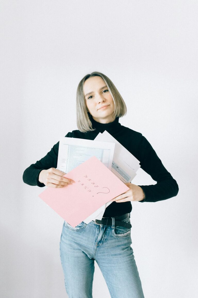 Confident woman holding tax documents in casual attire, ready for filing.